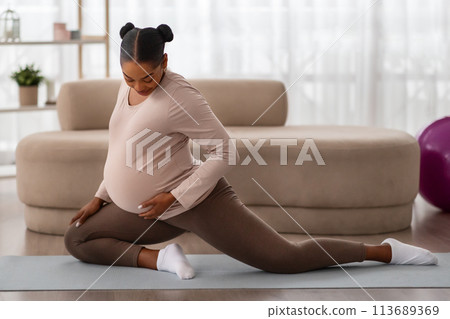 Pretty expectant woman doing domestic fitness, exercising indoors Pretty expectant woman doing domestic fitness, exercising indoors 113689369