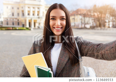 Selfie-taking woman student with a beaming smile 113689553