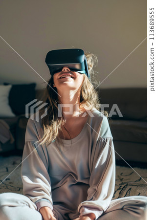 A woman is sitting on the floor wearing a virtual reality headset 113689555