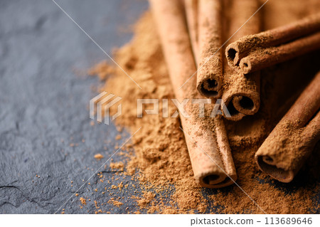 Cinnamon sticks and cinnamon powder on black slate plate 113689646