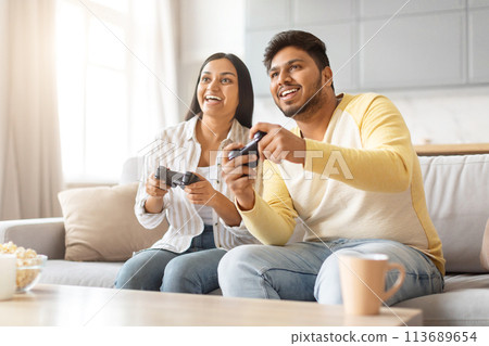 Indian Man and Woman Playing Video Game on Couch 113689654