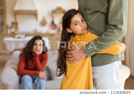 Girl hugging father with mother in background 113689685