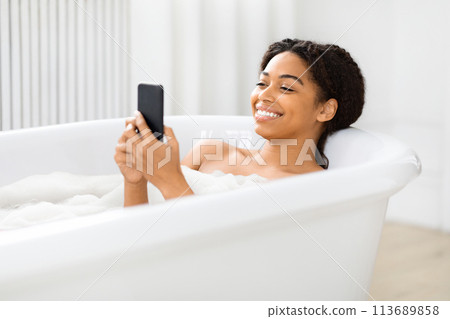 Woman using smartphone in the tub at home Woman using smartphone in the tub at home 113689858