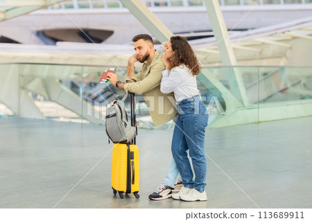 Couple with suitcase at a modern station, late on flight Couple with suitcase at a modern station, late on flight 113689911