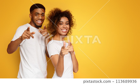 Joyful young couple pointing fingers at camera Joyful young couple pointing fingers at camera 113689936