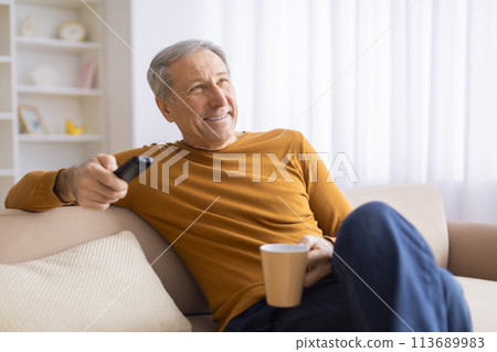 Mature man relaxing with remote and coffee 113689983