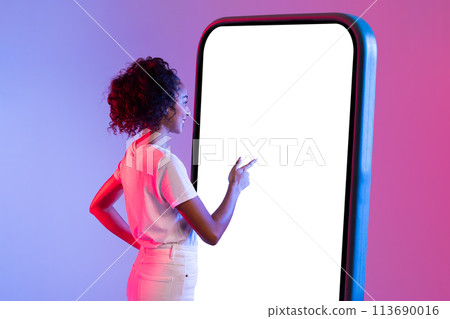 Woman interacting with giant smartphone screen 113690016