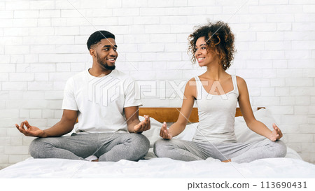 Young black family meditating in bed together Young black family meditating in bed together 113690431
