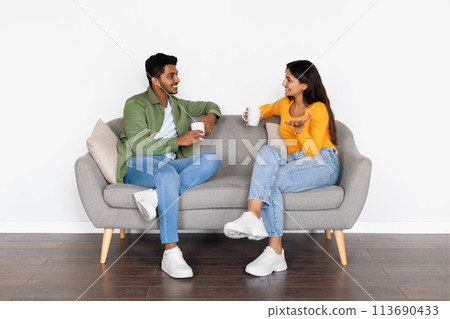 Indian spouses chatting over coffee on comfortable sofa Indian spouses chatting over coffee on comfortable sofa 113690433