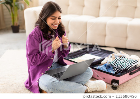 Excited middle eastern woman confirming travel plans 113690456