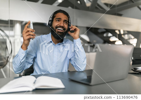 Smiling man with headset working in office 113690476