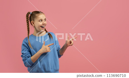 Excited girl pointing with both hands to side Excited girl pointing with both hands to side 113690710
