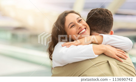 Happy Reunion. Joyful Young Woman Hugging Her Husband At Airport After Arrival 113690742
