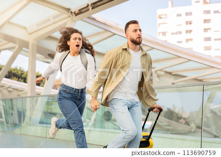 Stressed young couple running in airport terminal, late for their flight 113690759