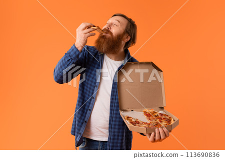Caucasian redhaired bearded guy enjoys cheat meal with pizza, studio 113690836