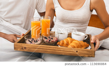 Happy black couple enjoying breakfast in bed Happy black couple enjoying breakfast in bed 113690864
