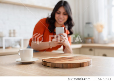 Selective focus on a coffee cup over woman taking photo Selective focus on a coffee cup over woman taking photo 113690874