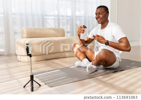 Man recording a fitness vlog at home 113691063