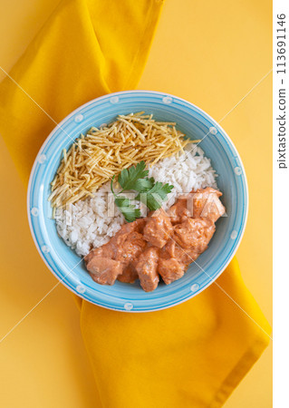 Chicken strogonoff with rice and potato straw on yellow Chicken strogonoff with rice and potato straw on yellow 113691146