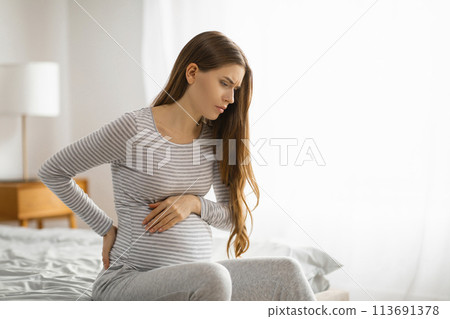 Pregnant woman feeling discomfort on the bed Pregnant woman feeling discomfort on the bed 113691378