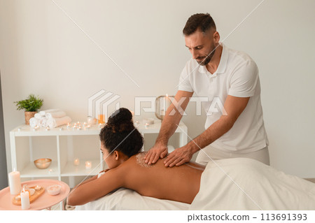 SPA worker giving massage to African American woman SPA worker giving massage to African American woman 113691393