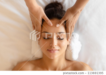 Closeup of young woman receiving relaxing head massage indoor 113691395