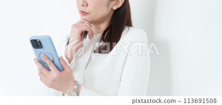使用智慧型手機的商務中年女性 使用智慧型手機的商務中年女性 113691508