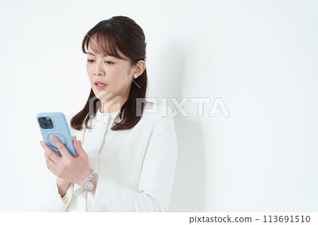 使用智慧型手機的商務中年女性 使用智慧型手機的商務中年女性 113691510