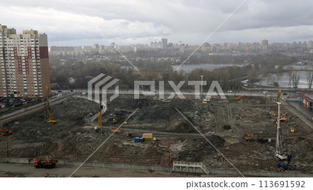Kiev, Ukraine March 13, 2019: Tractors and excavators work on the construction of the foundation zero cycle Kiev, Ukraine March 13, 2019: Tractors and excavators work on the construction of the foundation zero cycle 113691592