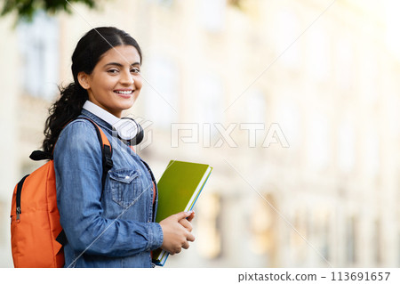 Happy Indian student with working books outside 113691657