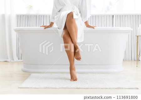 Elegant legs hanging over a bathtub edge 113691800