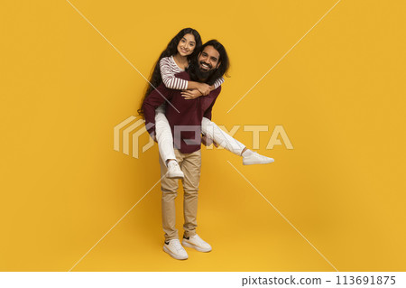 Man holding woman on side on yellow background 113691875