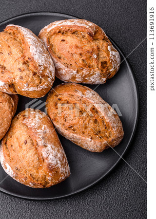 Fresh baked bread buns with salt, spices, seeds and grains Fresh baked bread buns with salt, spices, seeds and grains 113691916