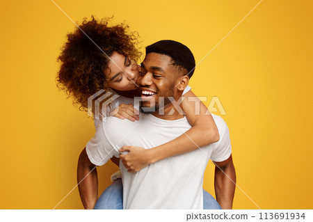 African american millennial couple fooling together, girl kissing her boyfriend 113691934