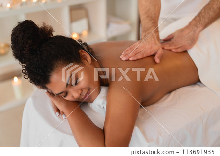 Woman receiving a relaxing back massage at spa 113691935