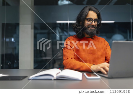 Man working on laptop in modern office 113691938