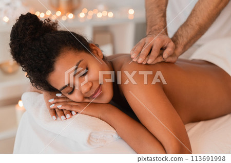 Woman enjoying a back massage at spa 113691998