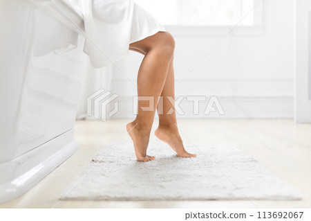 Luxurious freestanding tub with woman legs beside 113692067