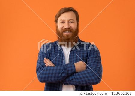 happy redhaired man with beard posing standing over orange backdrop happy redhaired man with beard posing standing over orange backdrop 113692105