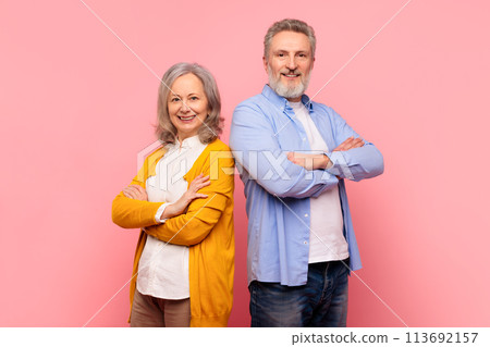 Mature couple posing with arms folded standing with confidence, studio Mature couple posing with arms folded standing with confidence, studio 113692157