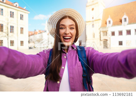 Cheerful young woman with outstretched arms taking selfie Cheerful young woman with outstretched arms taking selfie 113692181