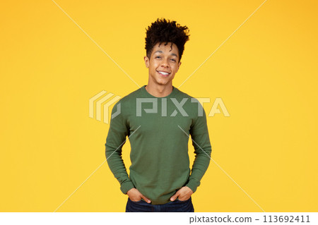 Young black man smiling on yellow background Young black man smiling on yellow background 113692411