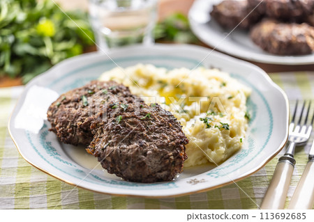 Minced meat cutlets with mashed potatoes topped with clarified butter. Traditional Slovak meatballs - Fasirky with potato puree. 113692685