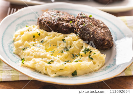 Mashed potatoes topped with melted butter as a side dish to meatballs Mashed potatoes topped with melted butter as a side dish to meatballs 113692694