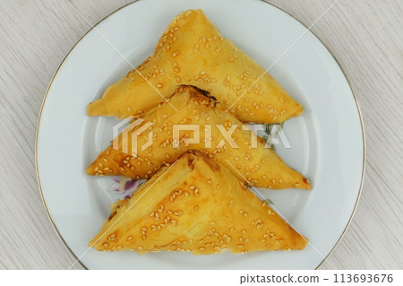 Eastern cuisine. Samosas in a plate on a white background. Homemade food. Fast food. Top view. 113693676