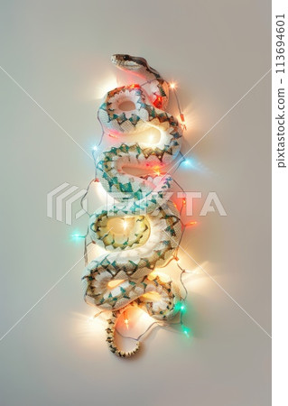 Enchanted Festive Serpent Wrapped in Christmas Lights and Pine 113694601