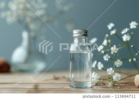 Serene Wellness Concept with Transparent Bottle and Delicate Flowers Serene Wellness Concept with Transparent Bottle and Delicate Flowers 113694711