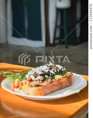 Healthy breakfast with srambled eggs, spinach and on toasted sourdough bread. 113694870