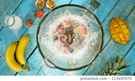 Freeze motion of mixing pieces of berries in blender with milk, top shot Freeze motion of mixing pieces of berries in blender with milk, top shot 113695076
