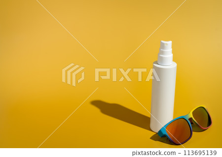 Blank white spray bottle with sunglasses in direct sunlight Blank white spray bottle with sunglasses in direct sunlight 113695139